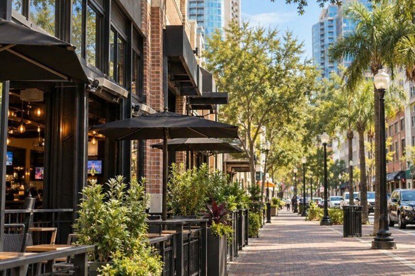 A city street lined with outdoor seating, trees, and buildings. 3