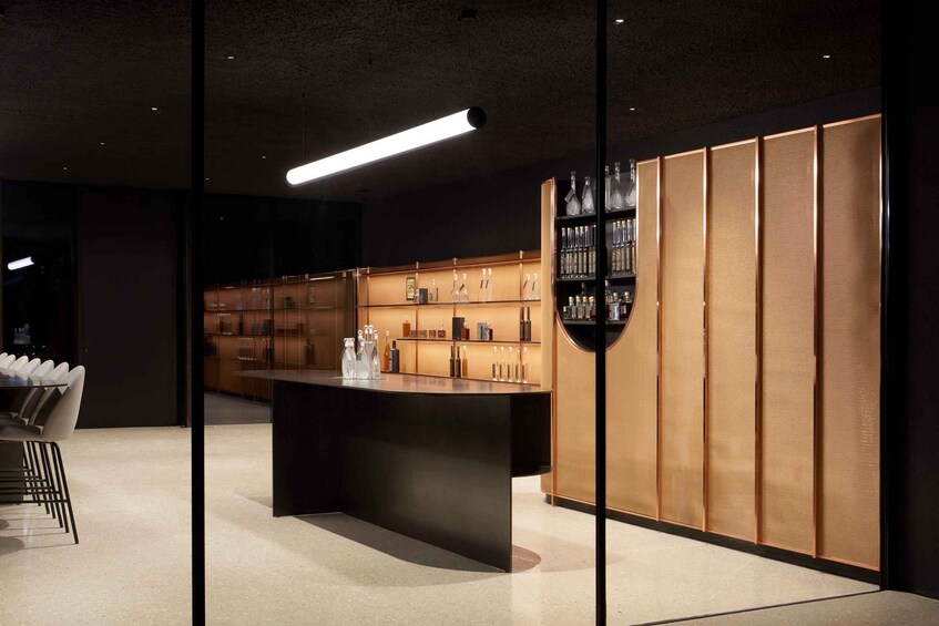 A modern interior with a bar area, wooden paneling, and glass shelves displaying bottles. 5