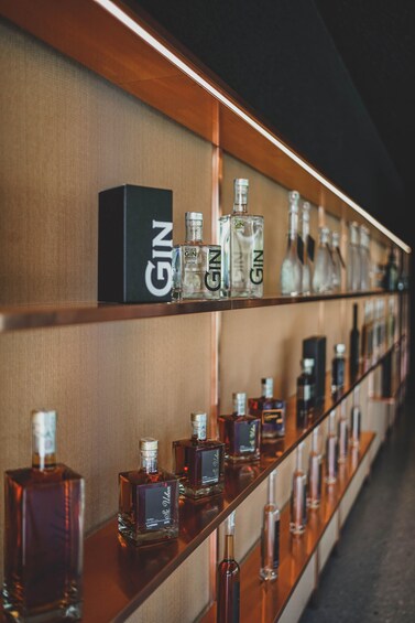 A display of gin bottles on shelves in a bar. 2