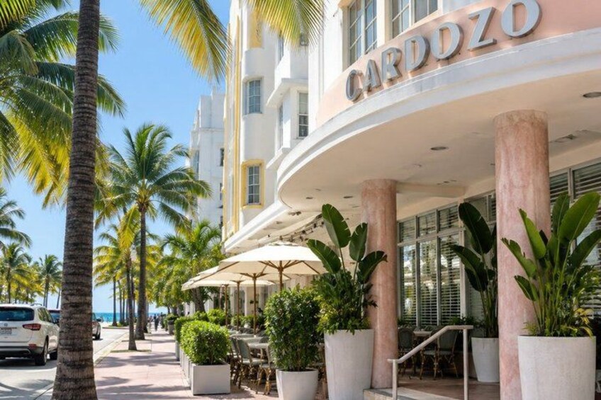 A hotel named Cardozo with palm trees and outdoor seating. 4