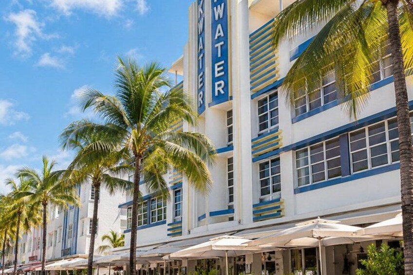 A beachfront hotel with palm trees and umbrellas. 2