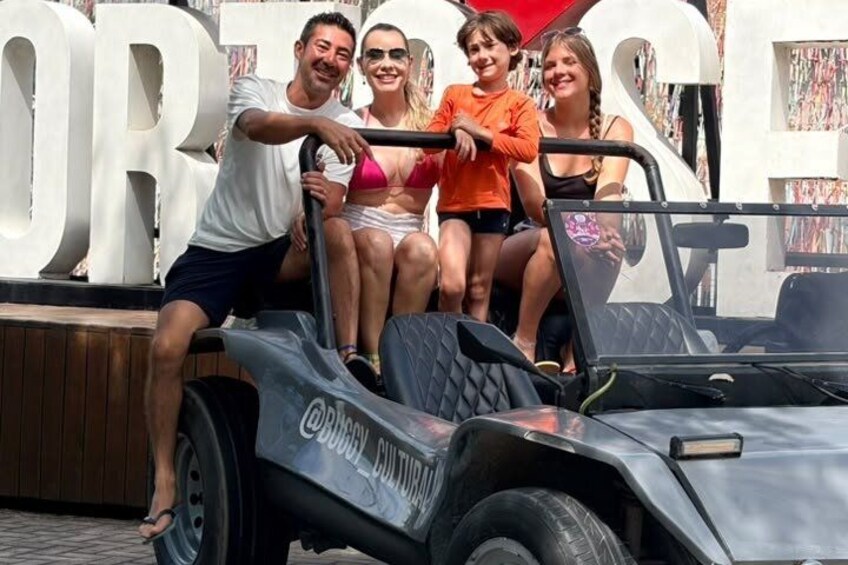 A group of people on a vehicle with a large number in the background. 1