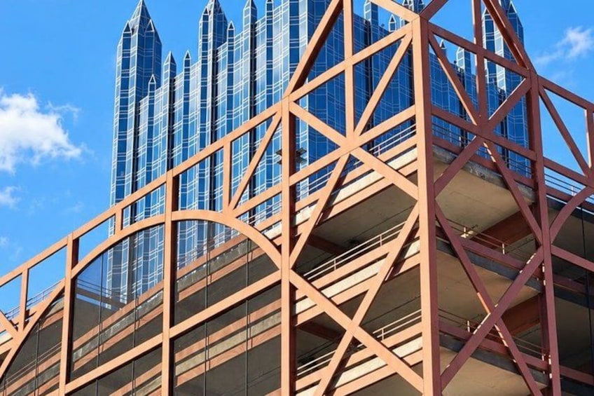 A modern architectural structure with a geometric metal framework and a glass facade. 4