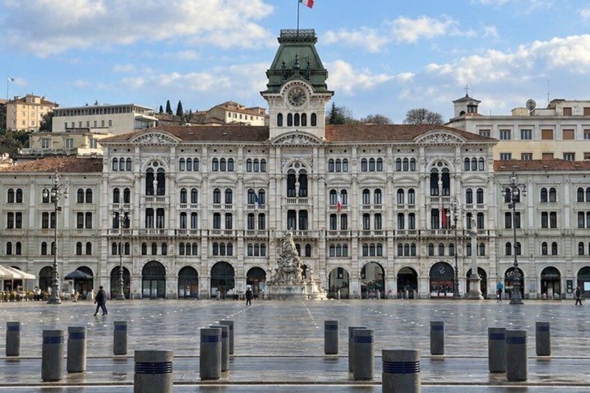 A historic building with a clock tower, arched windows, and a central fountain. 5