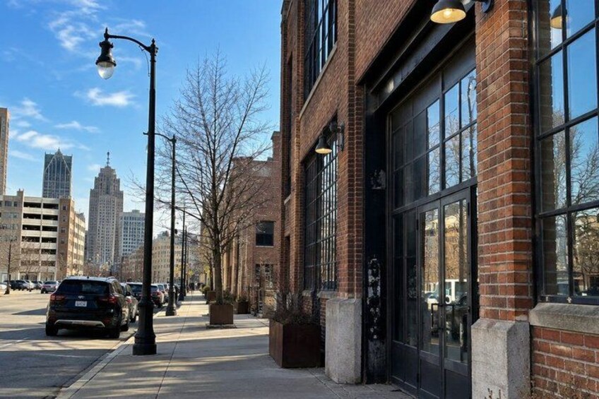 A street with brick buildings, a parked car, and a clear sky. 3