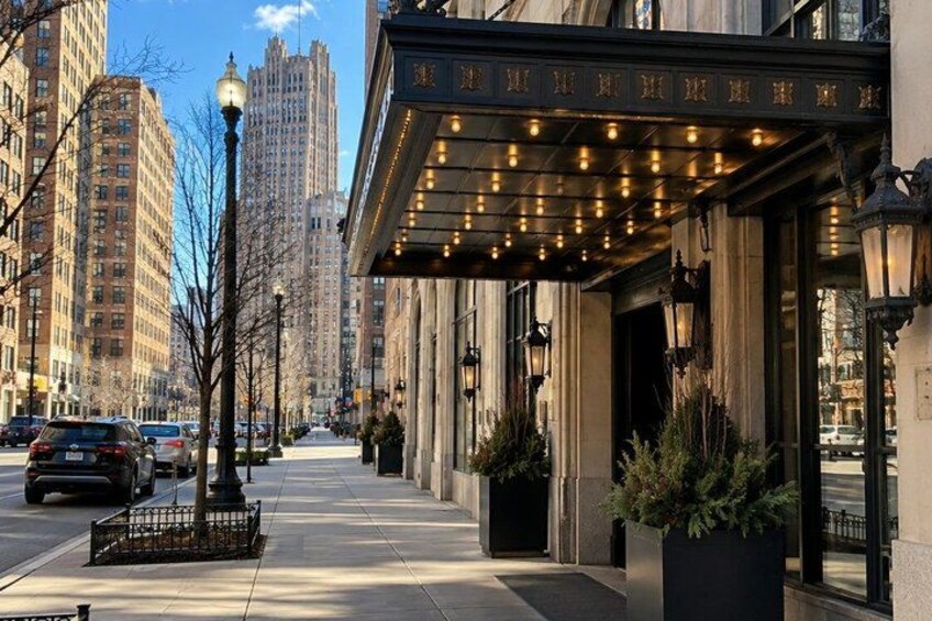 A city street with tall buildings, a sidewalk, and a building with a marquee. 1