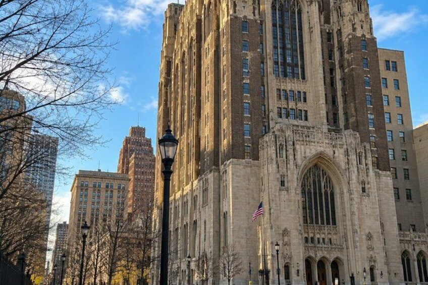 A historic building with intricate architecture, a flag, and surrounding modern high-rises. 5