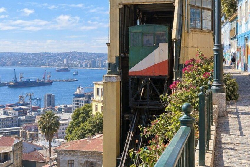 A coastal cityscape with a view of the sea, a green and white ship, and buildings along the waterfront. 2
