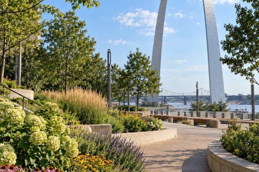 A landscaped pathway with a river and a bridge in the background. 2