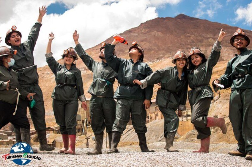 A group of people in work attire celebrating outdoors with a mountainous backdrop. 1