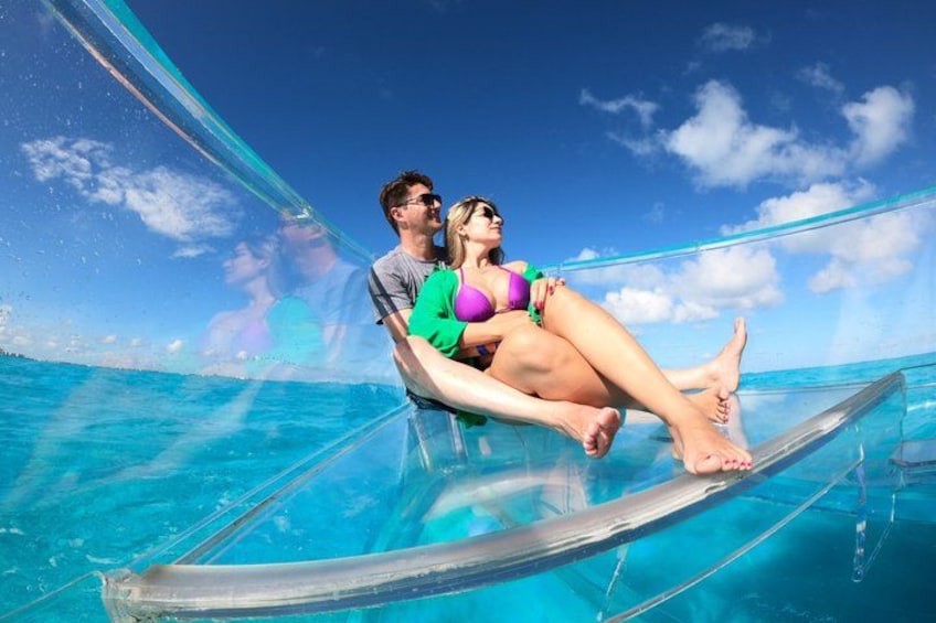 A couple on a transparent boat in clear blue water. 3