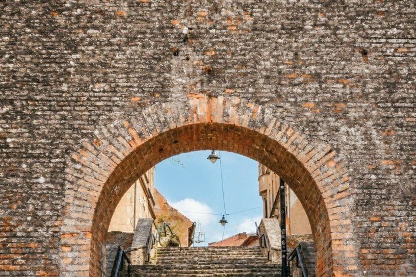 An arched brick structure with a staircase leading downwards. 3