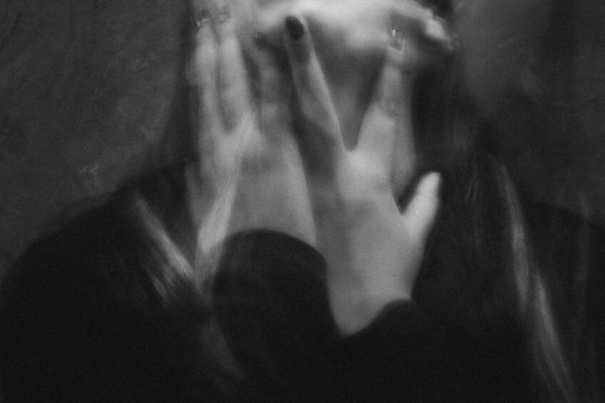 A person with their hands covering their face. 2