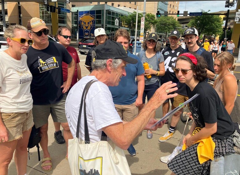 A group of people gathered on a city street, some wearing sports team apparel. 3