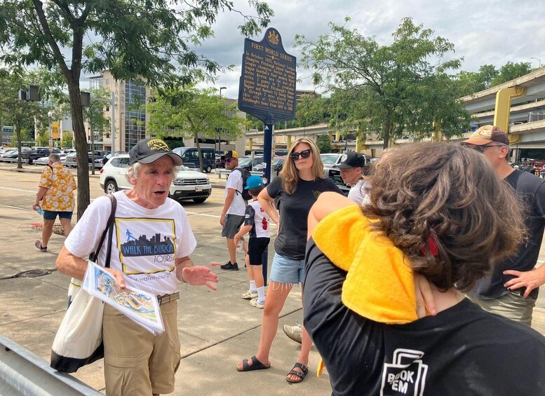 A group of people gathered around a historical marker sign. 5