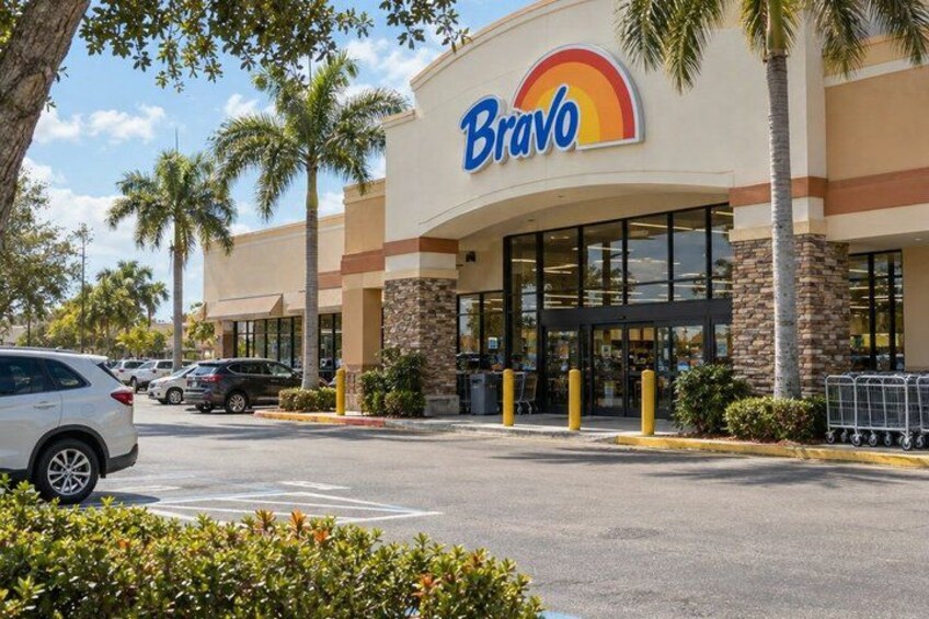 A Bravo store with palm trees and a parking lot. 2