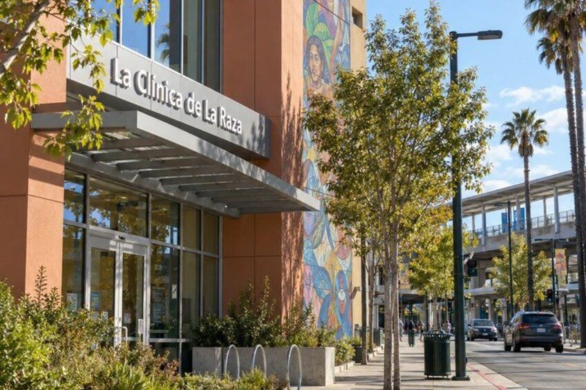 A building with a colorful mural and a sign that reads 'La Clinica de La Raza'. 2