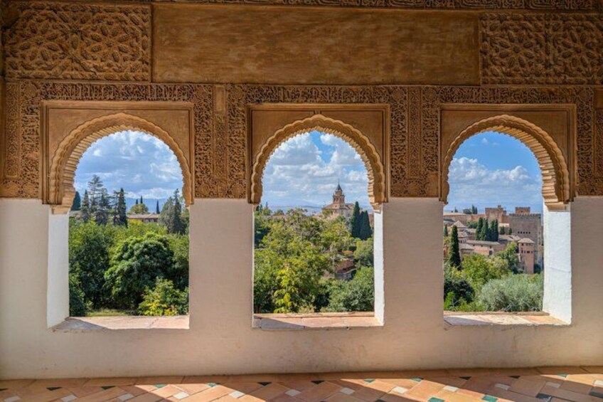 A view through ornate arches with a cityscape in the background. 2