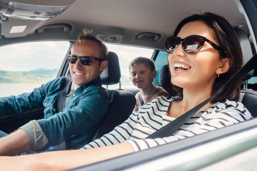 A car interior with a driver and two passengers. 1