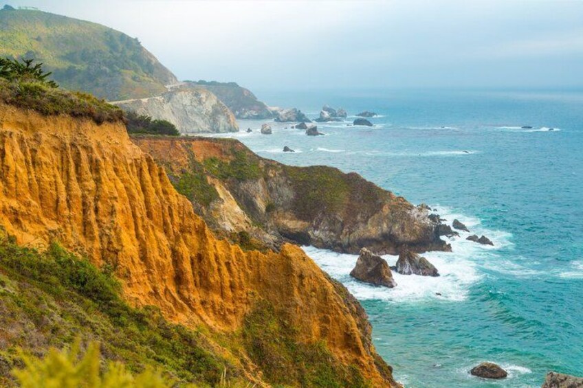 A coastal landscape with cliffs, ocean waves, and rocky outcrops. 4