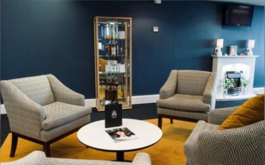 A room with two armchairs, a coffee table, a bookshelf, and a fireplace. 5