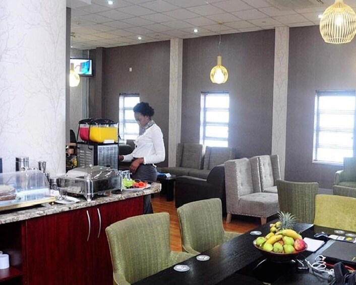 A modern dining area with a counter, chairs, and a table with fruit. 2