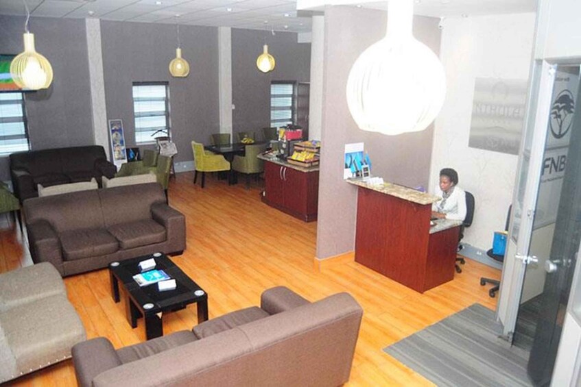 A modern office space with a reception desk, sofas, and a coffee table. 4