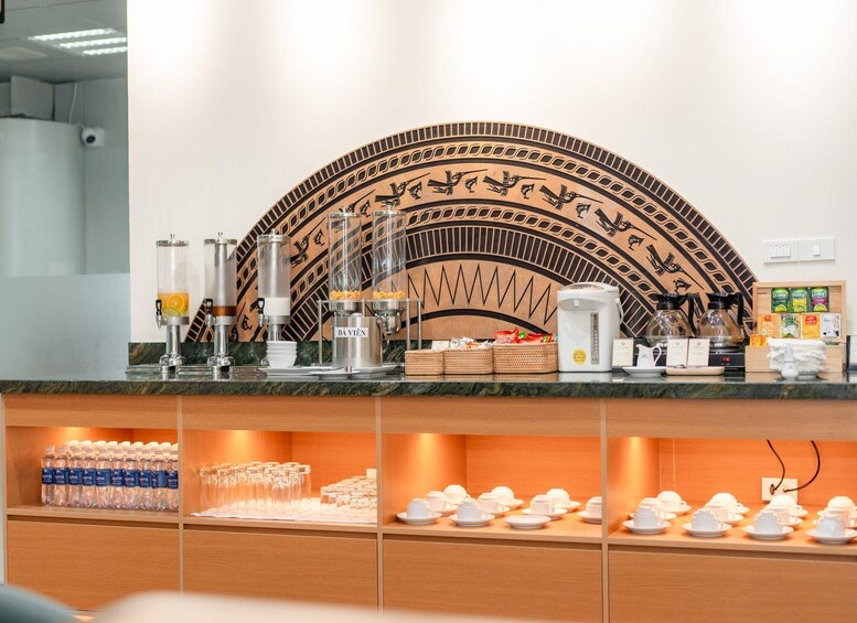 A coffee station with a decorative wall, coffee machines, and a variety of coffee cups and saucers. 4