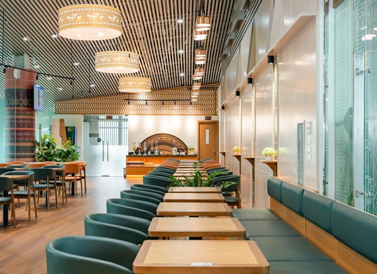 A modern interior with wooden flooring, green upholstered seating, and pendant lighting. 1