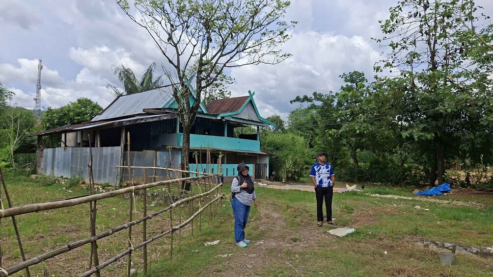 A rural house with a corrugated metal roof and a wooden fence. 1