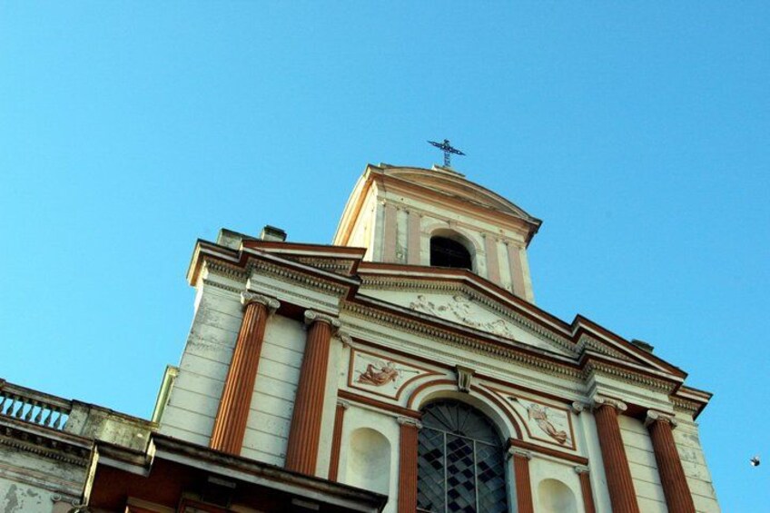A church with a bell tower and a cross on top. 4