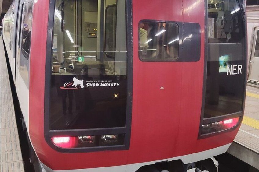 A red train with a window displaying a logo and text. 2