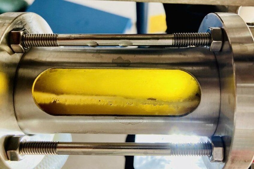 A metallic cylindrical object with a yellowish substance inside, surrounded by metal components. 4