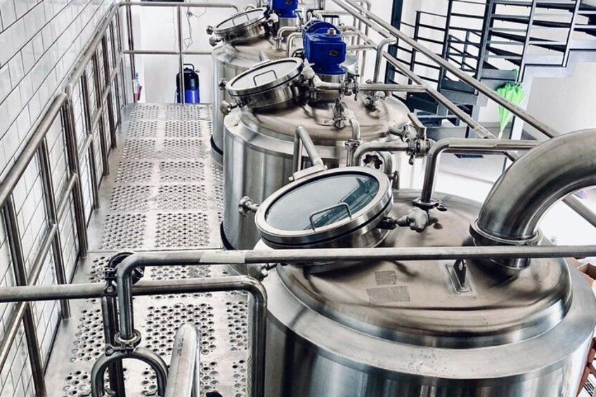 Stainless steel industrial equipment, including tanks and pipes, in a clean, well-lit facility. 2