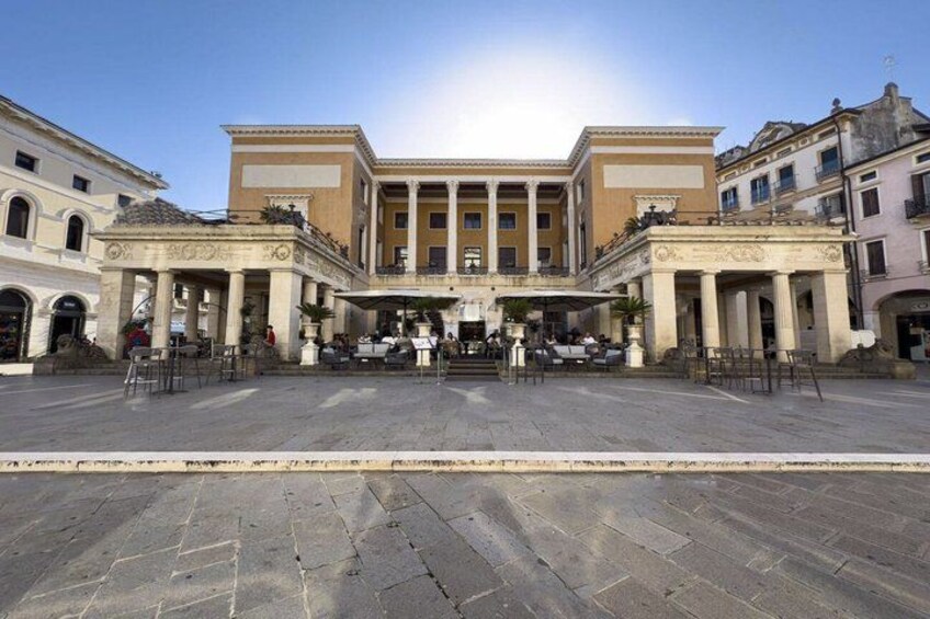 A historic building with classical architecture, a central courtyard, and surrounding structures. 2