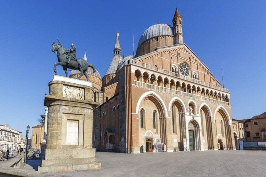 A historical building with a dome and arches, a statue of a horse and rider, and a clear blue sky. 5