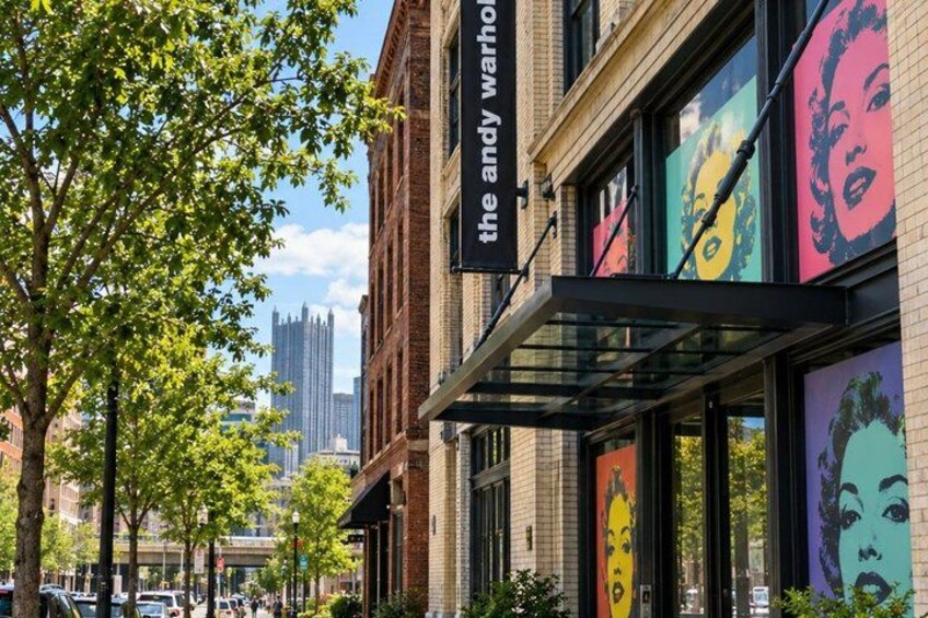 A street with a building featuring Andy Warhol's artwork. 4