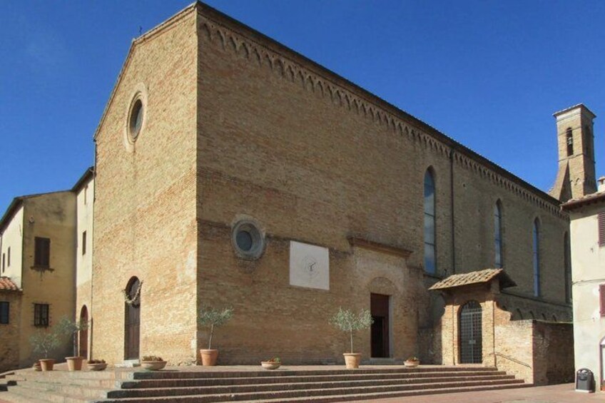 A historic building with a brick facade, arched windows, and a bell tower. 2