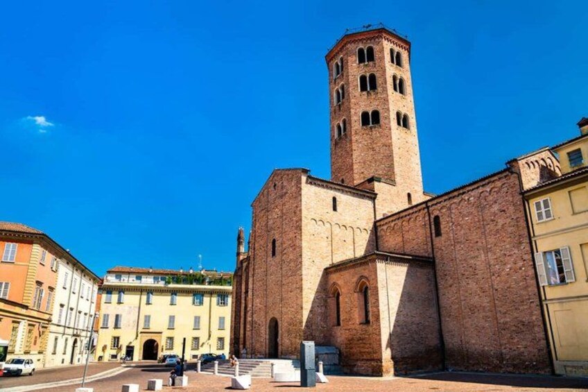 A historic building with a prominent tower, surrounded by other buildings. 3