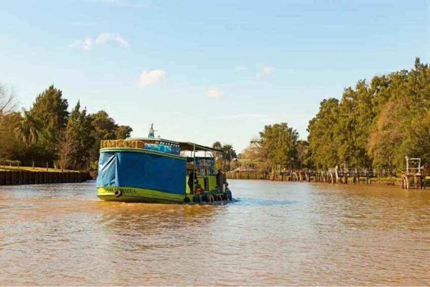 A blue and yellow boat on a river surrounded by trees. 1