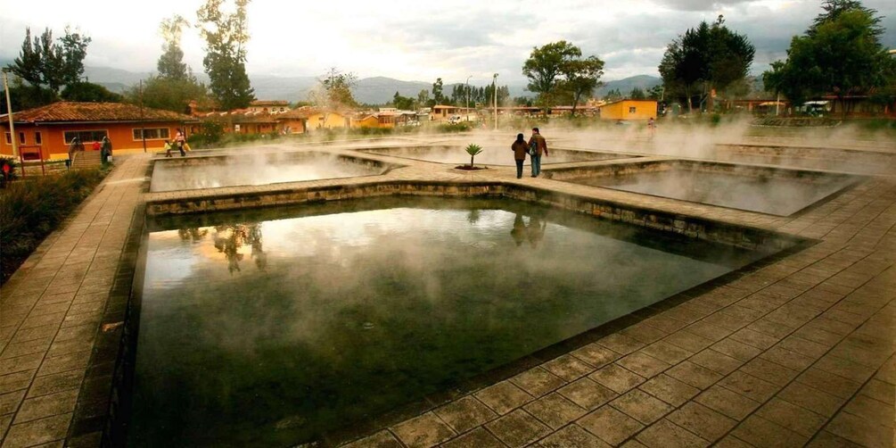 A geothermal spa with multiple hot springs and a large central pool surrounded by walkways. 2