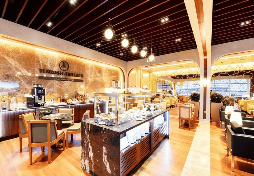 A modern cafe interior with marble walls, wooden furniture, and a buffet counter. 5