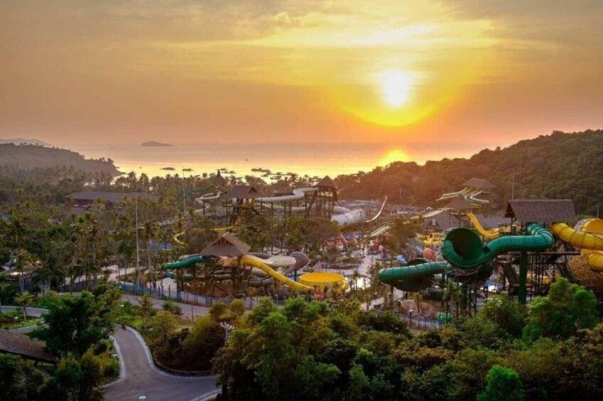 A water park with slides and a sunset in the background. 4