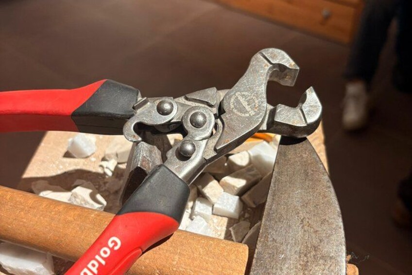 A pair of red-handled pliers with a metal jaw clamp. 3