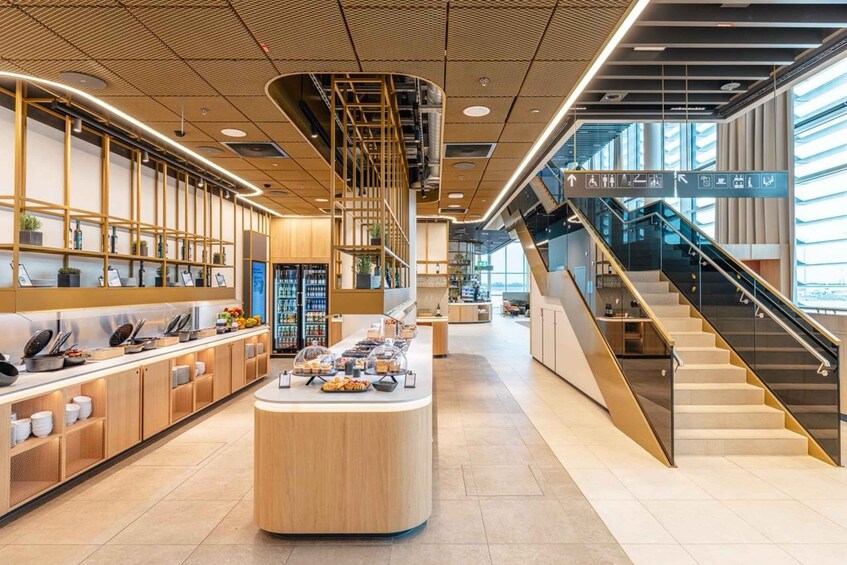 A modern interior with a central island, wooden shelving, and a staircase. 2