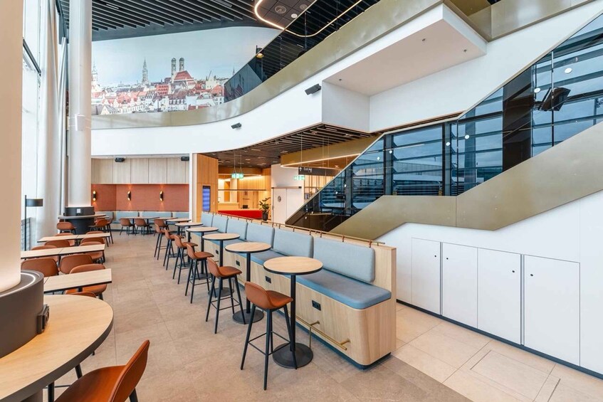 A modern interior with a café area, seating, and a staircase. 5