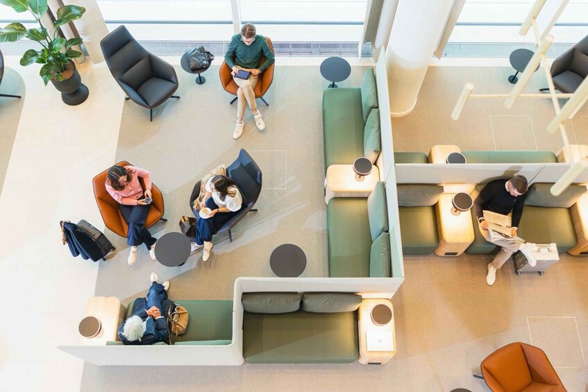 A modern waiting area with seating arrangements, a coffee table, and a potted plant. 4