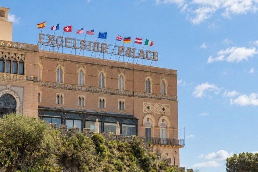 The exterior of the Excelsior Palace with multiple flags, including the Swiss flag. 4