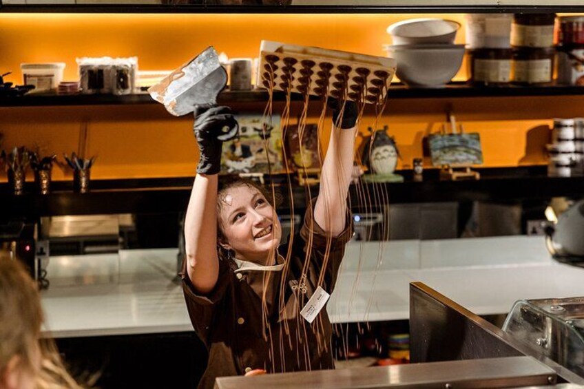 A person holding a large number of chopsticks above their head in a kitchen setting. 5