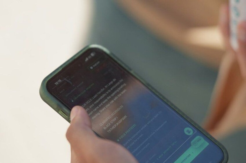 A person holding a smartphone with a dark screen displaying text. 5